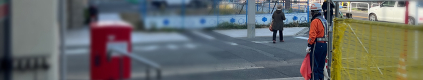 電線共同溝工事現場にて交通誘導する警備員