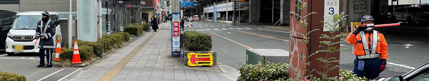 吹田市の店舗駐車場で車の入出庫を誘導中の警備員1