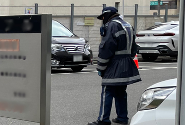 吹田市の店舗駐車場で車の入出庫を誘導中の警備員2