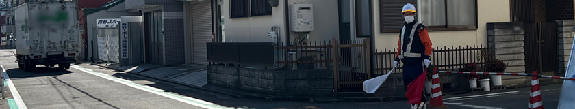 道路復旧工事現場で交通誘導警備中の警備員1