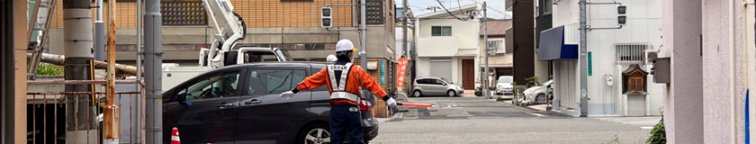 淀川区の信号機改良工事現場で交通誘導警備中の警備員1