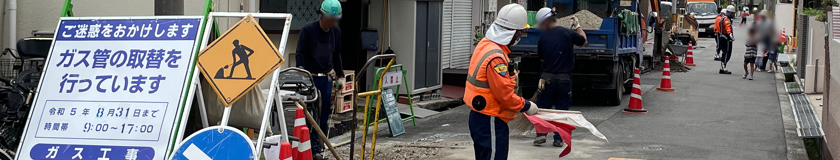 尼崎市のガス管取替工事現場で交通誘導警備中の警備員1の様子(2023.07.31)