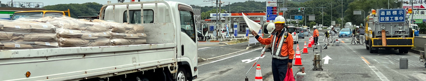 和泉市の交差点改良工事現場での交通誘導警備中の警備員1(2023.09.08)