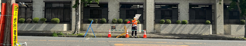 箕面市の電話設備工事現場での交通誘導警備中の警備員1(2025.05.15)