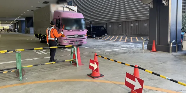 大阪オートメッセ2026の搬入口で車両誘導中の警備員
