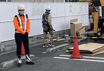 東大阪市のコンビニエンスストア駐車場内工事現場で通行者保全中の警備員(2026.03.13)